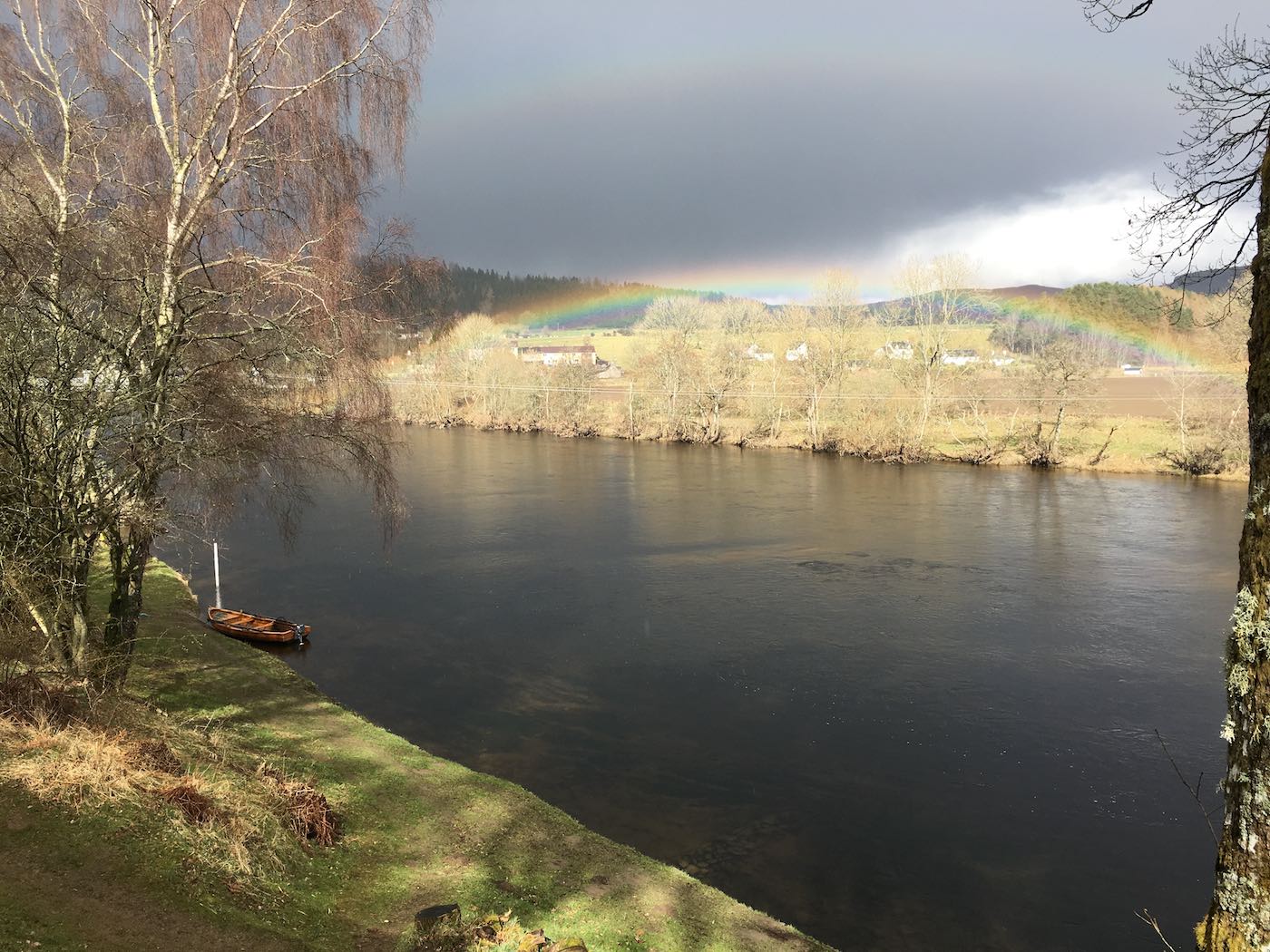 Here's an upstream shot taken from the Upper Kinnaird salmon fishing hut looking towards the traditional Tay salmon fishing boat and water gauge. Look atn the perfect rainbow stretching across the sky on the far riverbank. This is a very popular salmon fishing holiday destination on the River Tay.