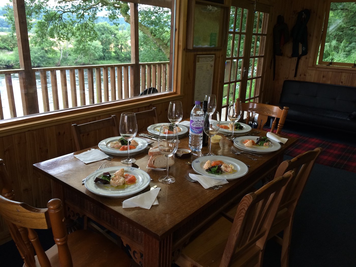 Look at this for professional chef fishing hut lunch table preparation. This is the Kinnaird salmon fishing hut near Dunkeld on a corporate hospitality event salmon fishing day. The table you see is made from solid oak and this big 8ft x 4ft window overlooks the River Tay which you can see through the balustrade.