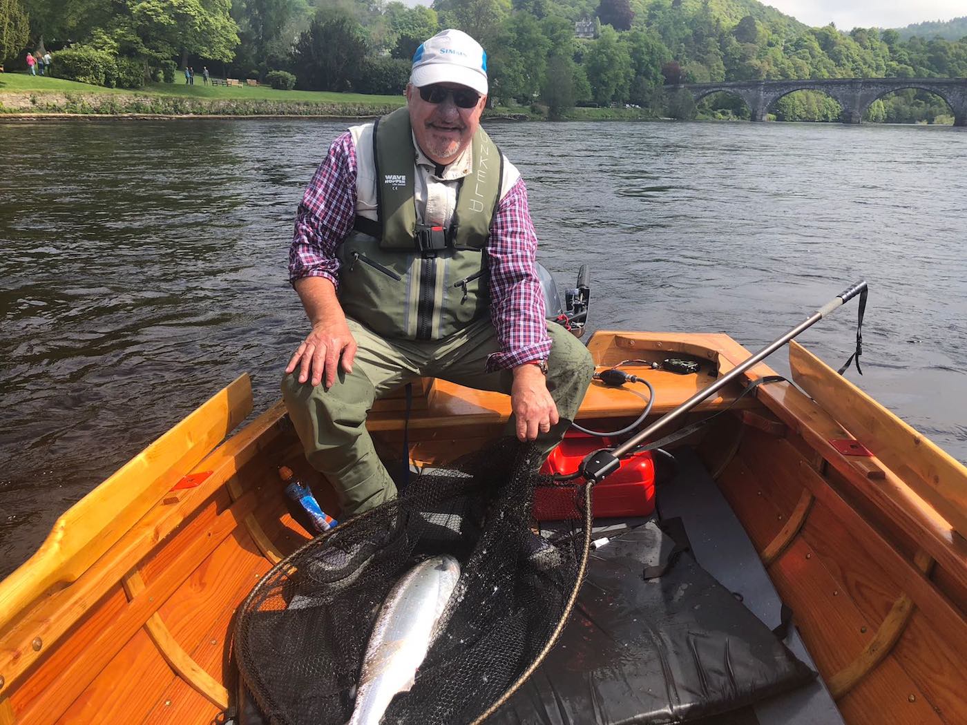 Here's a happy salmon fishing guide with the fine result of some perseverance from the traditional larch built River Tay salmon fishing boat. This Spring salmon was caught slightly upstream of the famous Telford Bridge at Dunkeld which is a great salmon fishing area of the Tay. This salmon was quickly released after this photograph was taken.