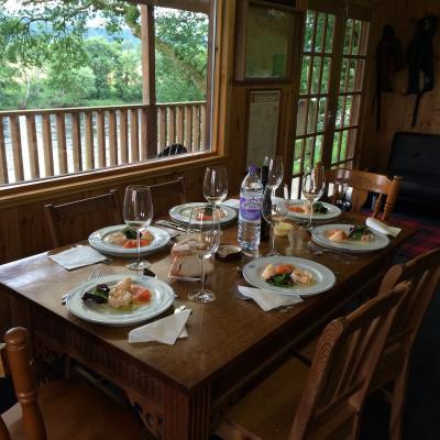 Look at this for professional chef fishing hut lunch table preparation. This is the Kinnaird salmon fishing hut near Dunkeld on a corporate hospitality event salmon fishing day. The table you see is made from solid oak and this big 8ft x 4ft window overlooks the River Tay which you can see through the balustrade.