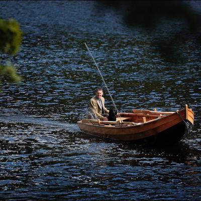 This fine shot of professional Scottish salmon guide Jock was taken in the Cottar Pool of the River Tay near Dunkeld and was taken by professional Glasgow based photographer Peter Sandground for the Glasgow Herald Magazine. Jock's black labrador is sitting in the bow of the boat.