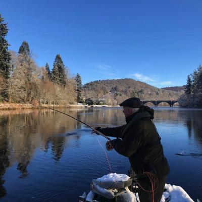 This River Tay fly fisher is Spey casting from the traditional Tay salmon fishing boat during late January on the Tay at Dunkeld. If you look closely you'll see the 200 year old Telford Bridge in the distance which is one of the Tay's most historic & beautiful sandstone bridges.