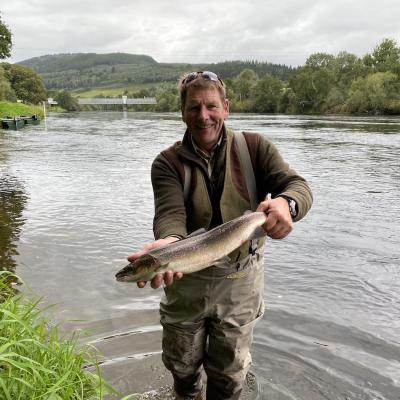 This professional guide from the River Dee is holding 1 or 3 salmon landed that August day. John Fyfe came down from the River Dee to be guided by Jock Monteith who is renowned for his excellent guiding abilities. This salmon was caught on the Upper Kinnaird salmon beat at the Daffodil Lie Pool which is immediately downstream of the Logierait Bridge which is clearly visible in this picture.