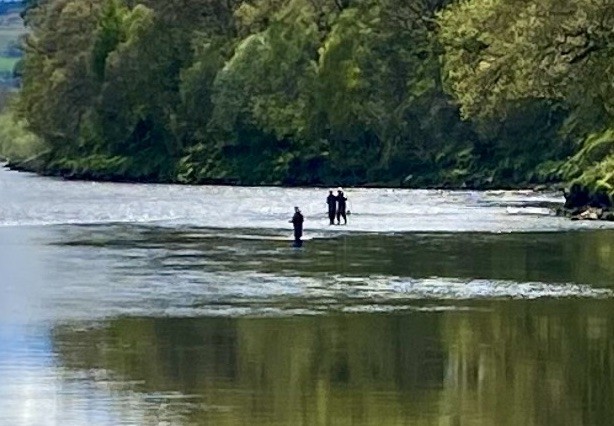 This zoomed in shot was taken by me from the Rock Pool on Upper Kinnaird looking downstream to a party of 2 fishers accompanied by their professional salmon guide the moment a perfect 12lbs Spring salmon was landed which is barely visible in the landing net in this shot. The River Tay is a great Scottish salmon river even in low bright water conditions and this guest went on to land another salmon of similar size moments after this fine river shot was captured.