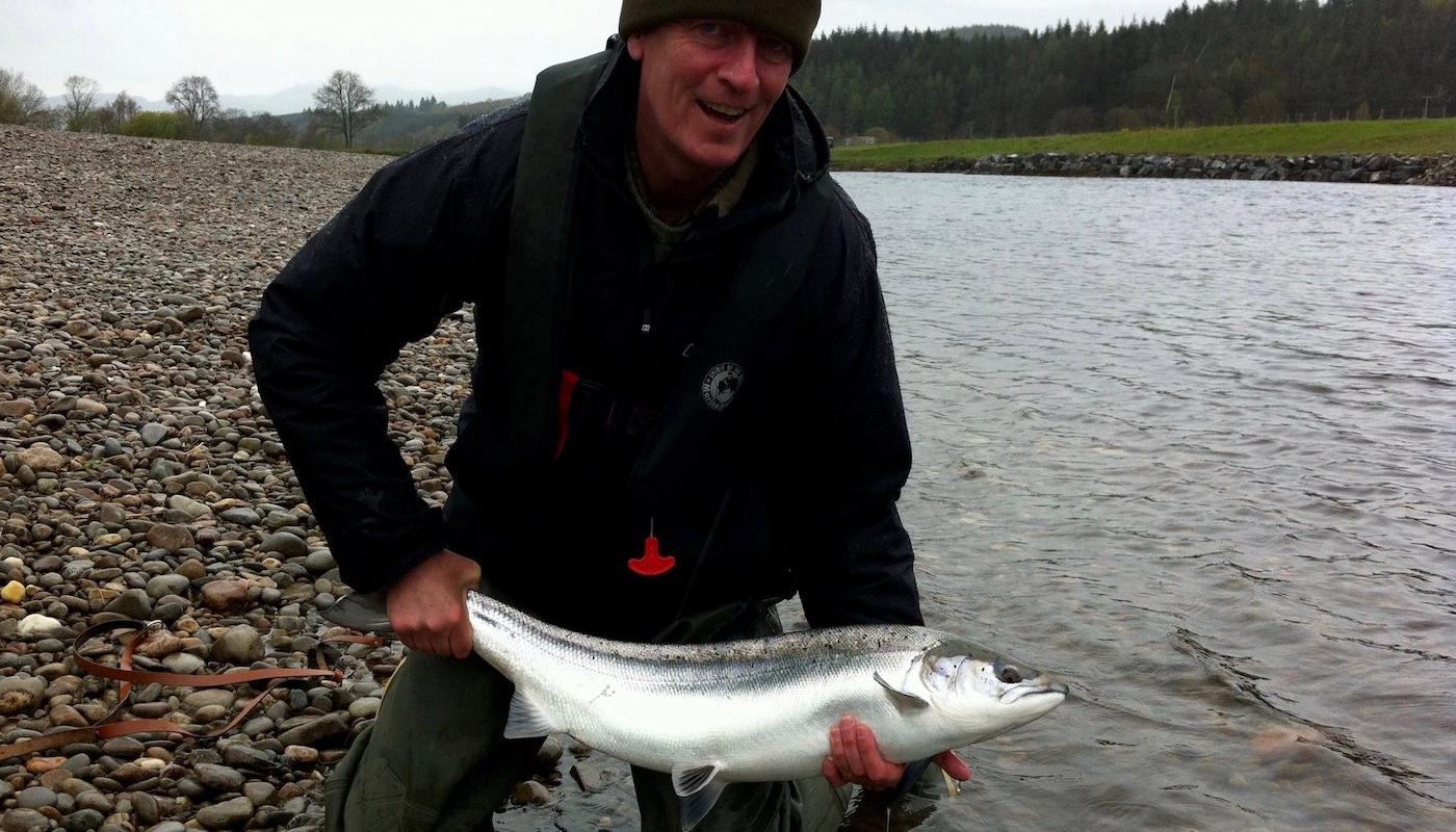 This perfect salmon was landed during rough weather conditions on the beautiful & productive Guay Pool of the River Tay near Dunkeld. This fine fish weighed 12lbs and was soon released to the river to continue its upstream journey. This was this Irish fisher's first Scottish salmon hence the big smile. I took this salmon capture shot while working as this salmon fishing guest's personal salmon guide that day.